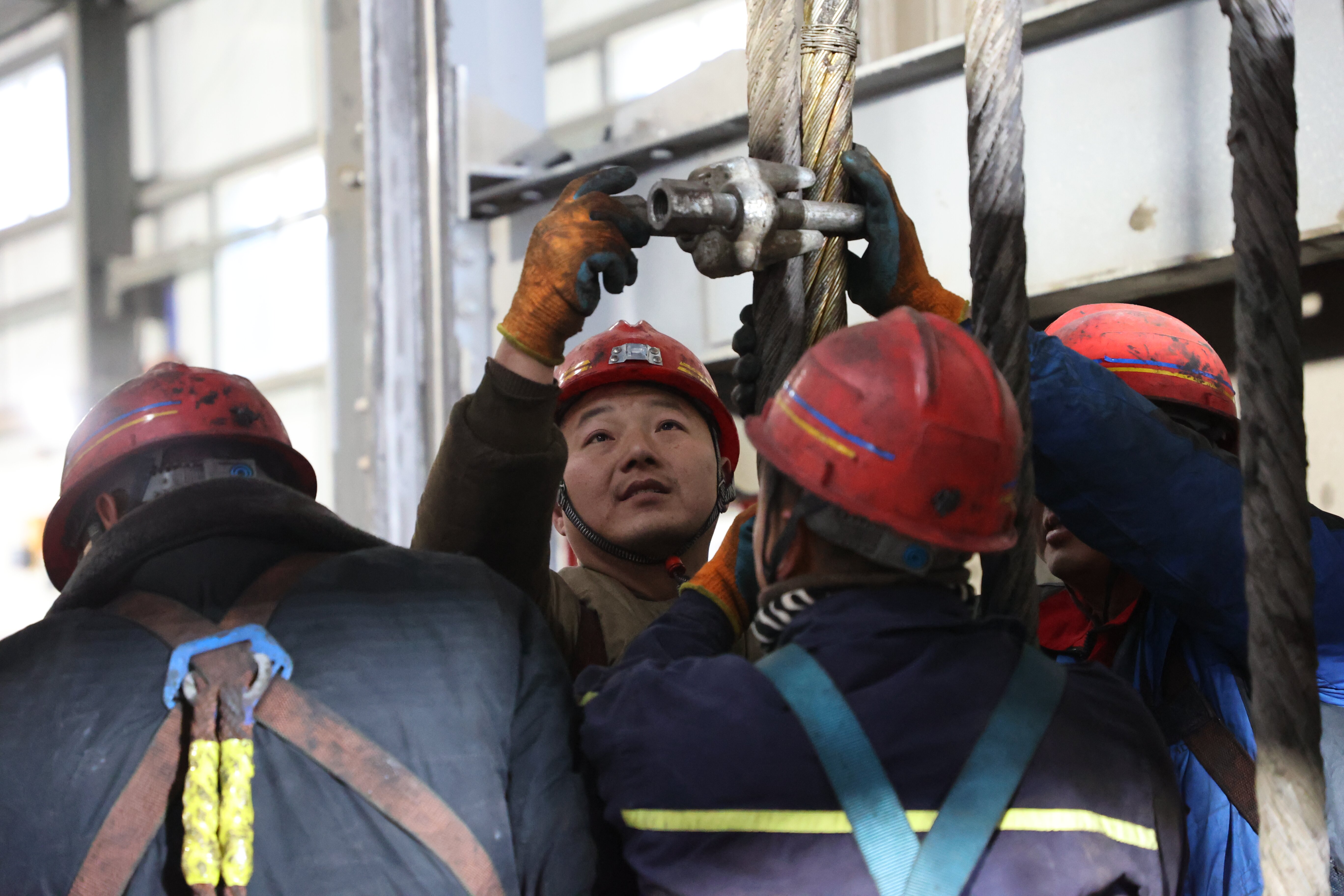 西卓煤礦機(jī)電隊(duì)職工正在對(duì)副井寬罐提升鋼絲繩進(jìn)行更換 (3)_proc.jpg